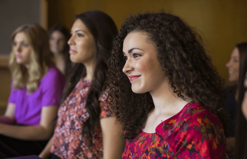 Young women sit in a class together.