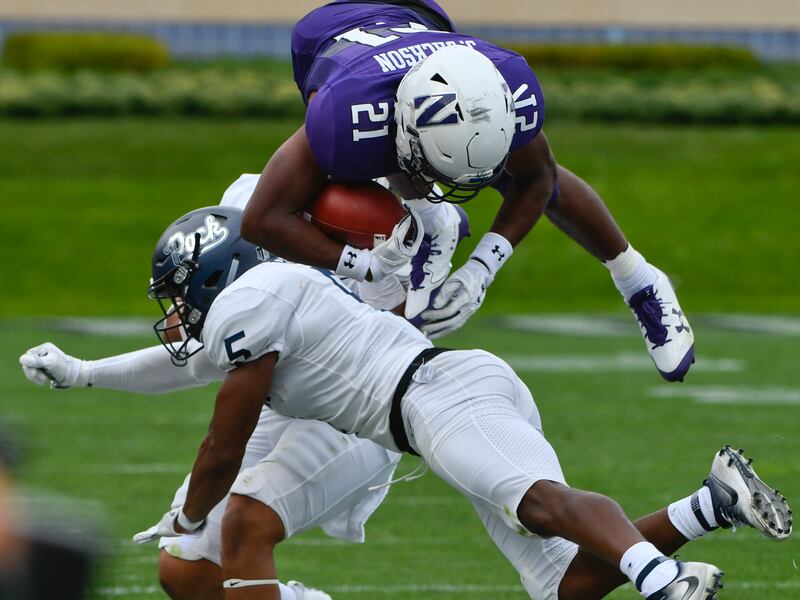 Northwestern running back Justin Jackson (21) gets flipped in the air by Nevada linebacker Gabriel Sewell, back, and Nevada defensive back Dameon Baber (5) during the first half of an NCAA college football game in Evanston, Ill., Saturday, Sept. 2, 2017.