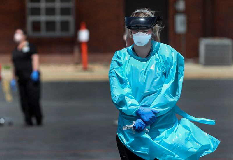 Shelby Close, a certified medical assistant with University of Utah Health, holds a COVID-19 test kit as she waits for a car to arrive at a testing facility in Park City on Wednesday, May 6, 2020.