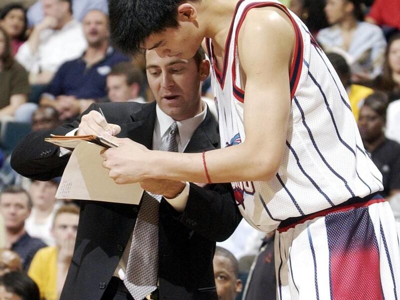 Houston Rockets assistant coach Mike Wells goes over a play with Yao Ming during a preseason game against the Philadelphia 76ers on Thursday, Oct. 24, 2002, in Houston. The 76ers beat the Rockets 93-89. (AP Photo/David J. Phillip)