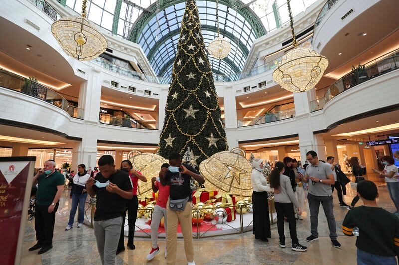 Tourists near a giant Christmas tree at a shopping mall in Dubai, United Arab Emirates.
