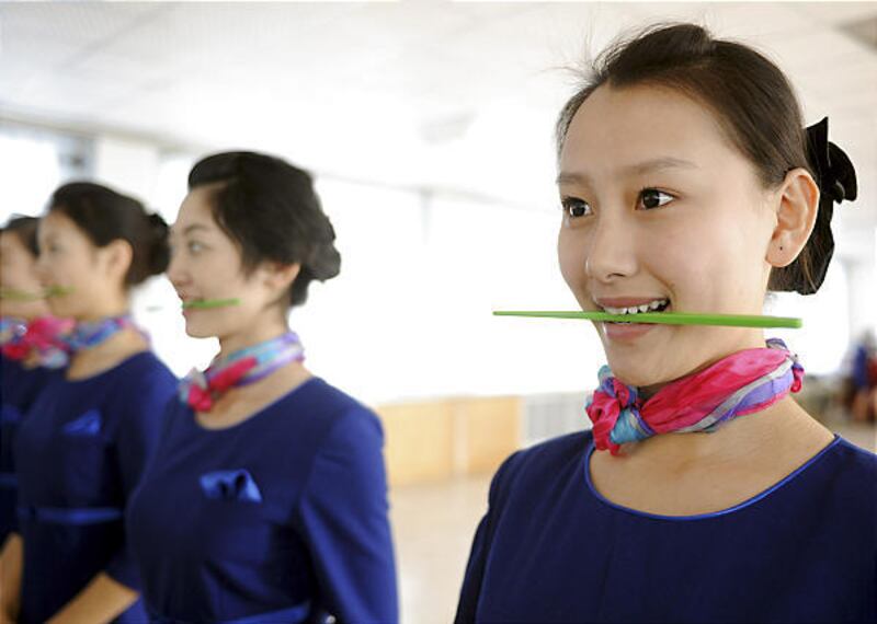 Women practice smiles during training Tuesday in Qingdao in east China's Shandong Province. Of 2,000 applicants, 110 women were chosen to serve as stewards and ushers for the 2008 Beijing Olympics.