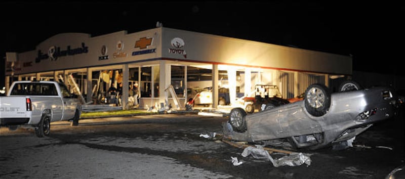 An overturned car sits in the lot of Jim Robertson car dealership after it was hit by a tornado Wednesday in Kirksville, Mo. Multiple tornadoes hit the area as severe storms tore through the state.