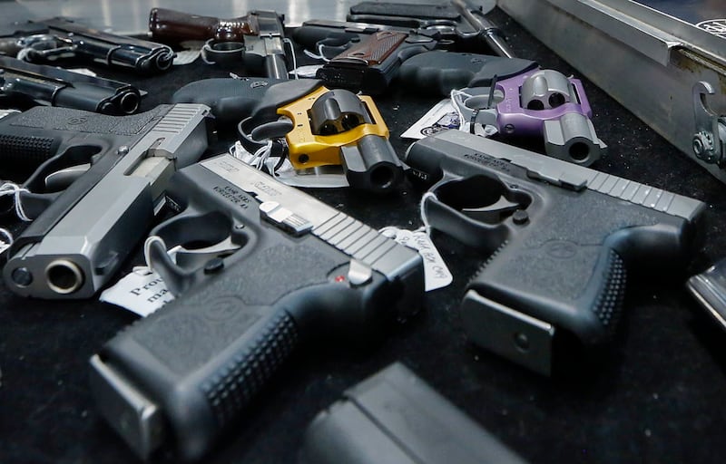 FILE - In this Jan. 26, 2013, file photo, handguns are displayed on a vendor's table at an annual gun show in Albany, N.Y.