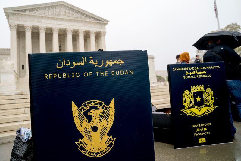 Poster sized enlargements of passports are on display during an anti-Muslim ban rally as the Supreme Court hears arguments about wether President Donald Trump's ban on travelers from several mostly Muslim countries violates immigration law or the Constitu