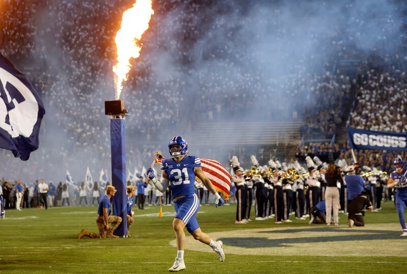 BYU players run onto the field to play the Cincinnati Bearcats at LaVell Edwards Stadium in Provo on Friday, Sept. 29, 2023.