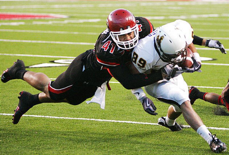 Wyoming wide receiver Zach Bolger (89) is tackled from behind by Utah defensive end Koa Misi (41) at Rice-Eccles Stadium in Salt Lake City Saturday.