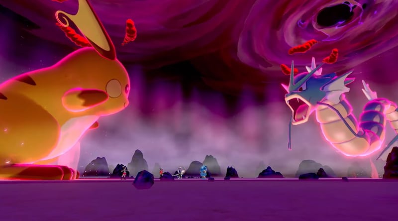 Two Dynamaxed Pokemon fight against each other in a four-player raid battle in "Pokemon Sword" and "Shield" for Nintendo Switch.