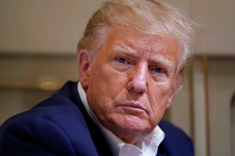 Former President Donald Trump listens as he speaks with reporters after a campaign rally at Waco Regional Airport in Waco, Texas.