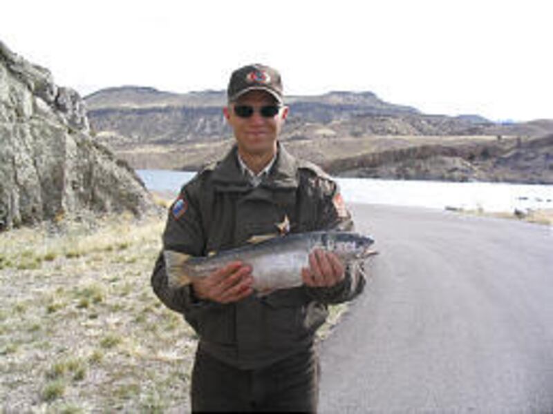 Panguitch Conservation Officer Micah Evans with a rainbow trout collected during gillnetting at Piute Reservoir in March.