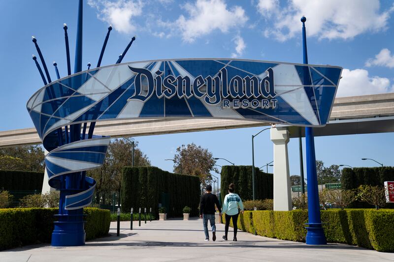 Two visitors enter Disneyland Resort in Anaheim, California.