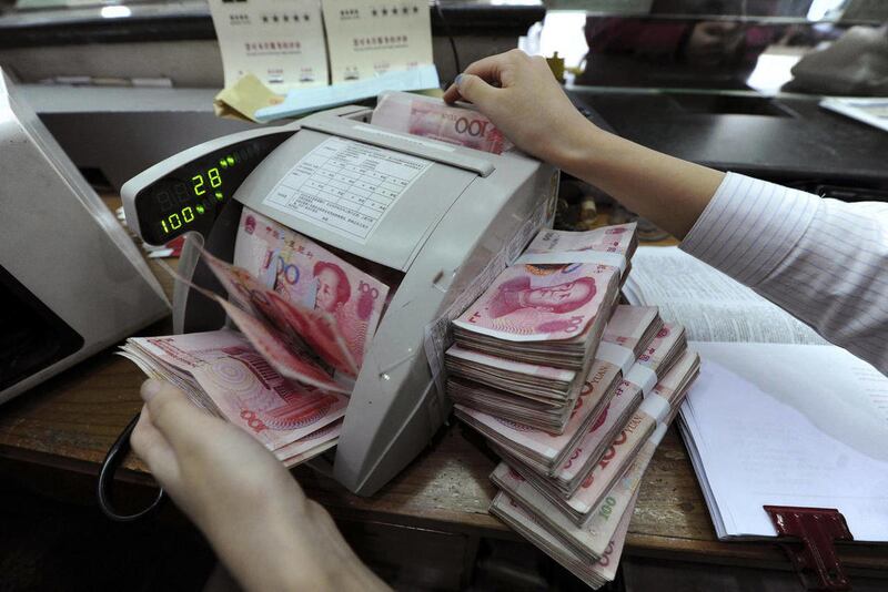 FILE - In this Oct. 20, 2010 file photo, a bank clerk uses a machine to count renminbi banknotes in a bank in Hefei in central China's Anhui province. A state-owned Chinese bank says its New York City branch has begun offering accounts denominated in Chin