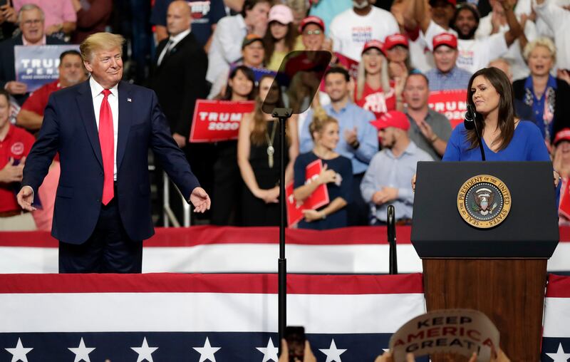 Then-President Donald Trump smiles as Sarah Sanders speaks at a rally where Trump announced his 2020 reelection bid.