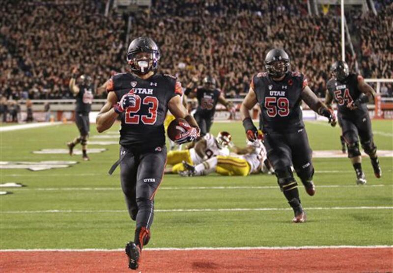 Utah running back Devontae Booker (23) carries the ball for a touchdown in the fourth quarter during an NCAA college football game against Southern California Saturday, Oct. 25, 2014, in Salt Lake City. Utah won 24-21. (AP Photo/Rick Bowmer)