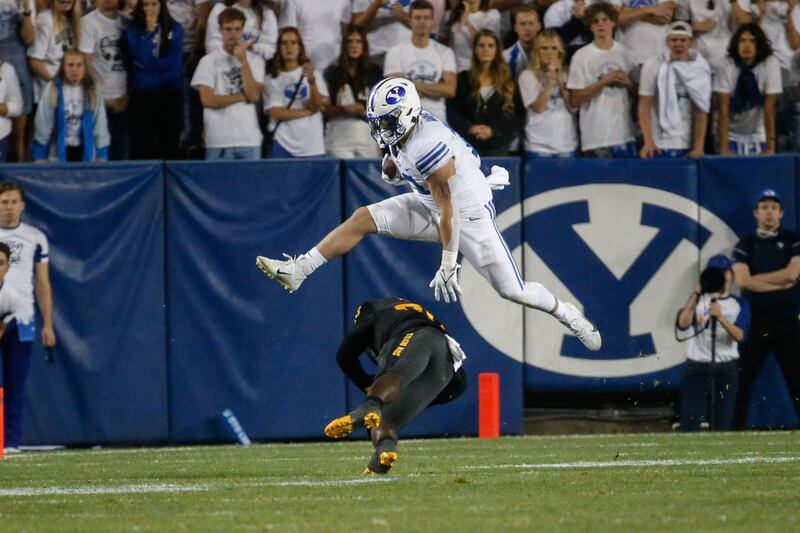 BYU fullback Masen Wake dodges a tackle by Arizona State’s Giovanni Sanders (20) during a game at LaVell Edwards Stadium in 2021.