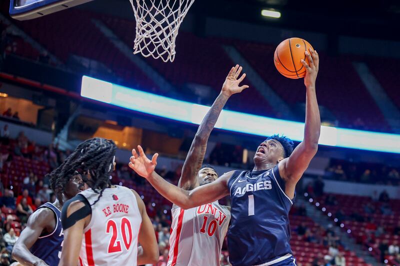 Utah State forward Great Osobor (1) shoots over UNLV forward Kalib Boone (10) during the second half of an NCAA college basketball game Saturday, Jan. 13, 2024, in Las Vegas. (AP Photo/Ian Maule)