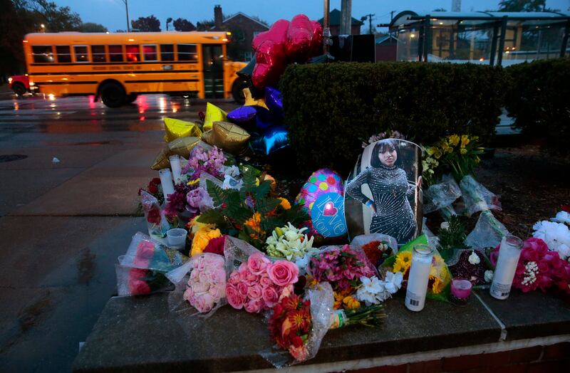A photo of Alexandria Bell rests at the scene of a growing floral memorial to the victims of a school shooting in St. Louis.