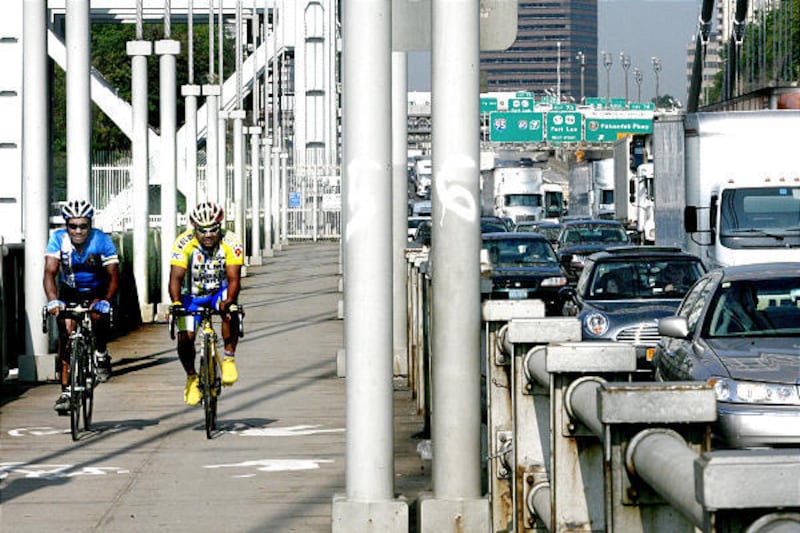 Two cyclists make their way along morning traffic from Fort Lee, New Jersey, via the George Washington Bridge and into New York City, Septembr 1, 2010.