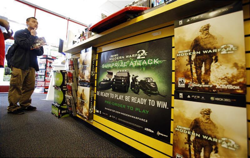 A customer stands near A Call of Duty: Modern Warfare 2 sign posted at a GameStop in Redwood City, Calif.