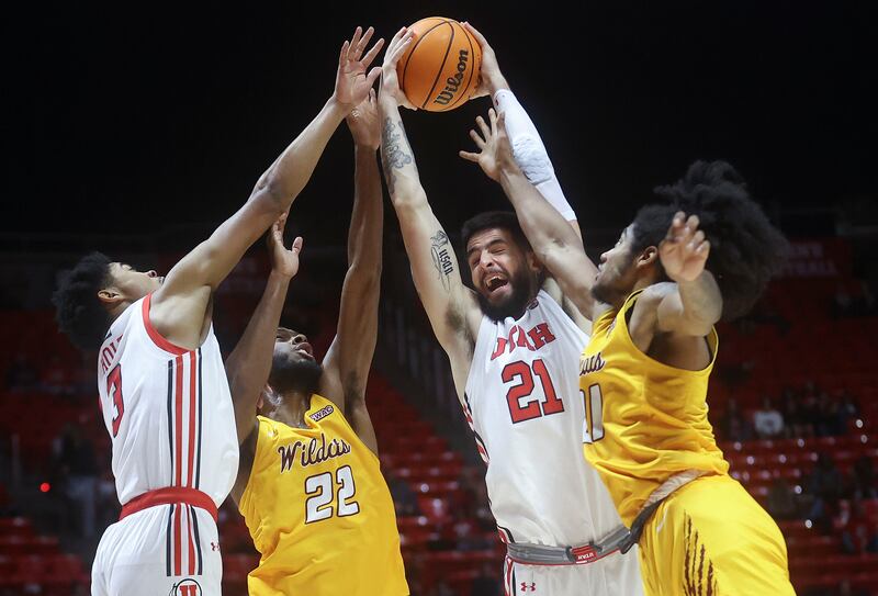 Utah forward Dusan Mahorcic (21) battles for the ball with a pair of Bethune-Cookman Wildcats in Salt Lake City.
