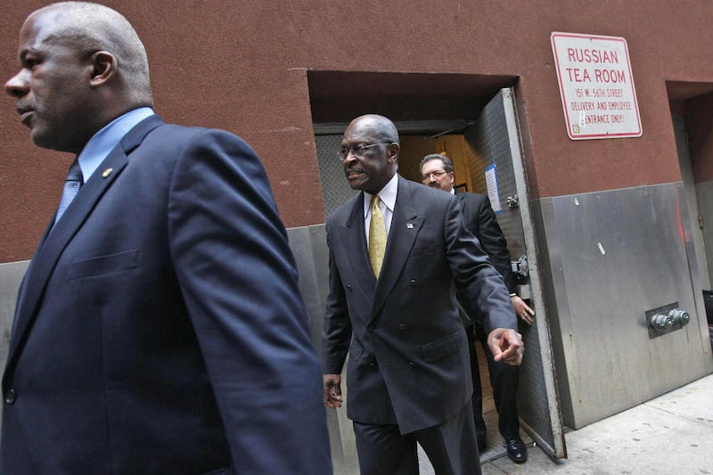 Republican presidential candidate Herman Cain is escorted by security as he leaves the back door of the Russian Tea Room after a fundraiser, Friday, Nov. 11, 2011, in New York.