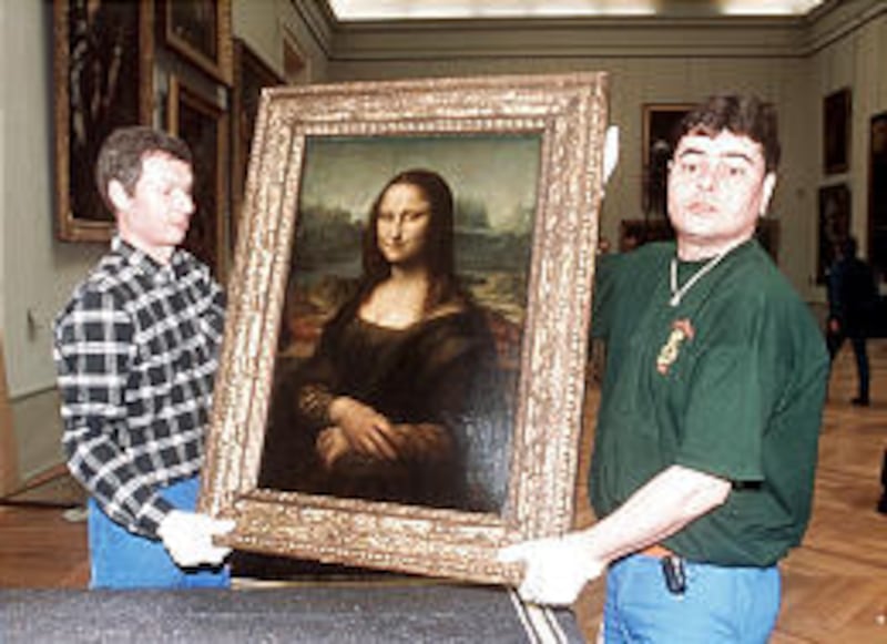 Employees of the Louvre hold the “Mona Lisa” in the museum.