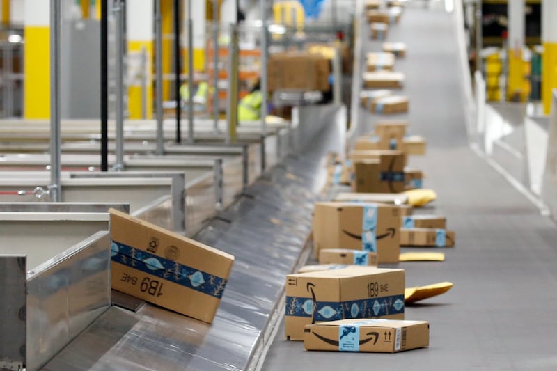 Amazon packages move along a conveyor at an Amazon warehouse.