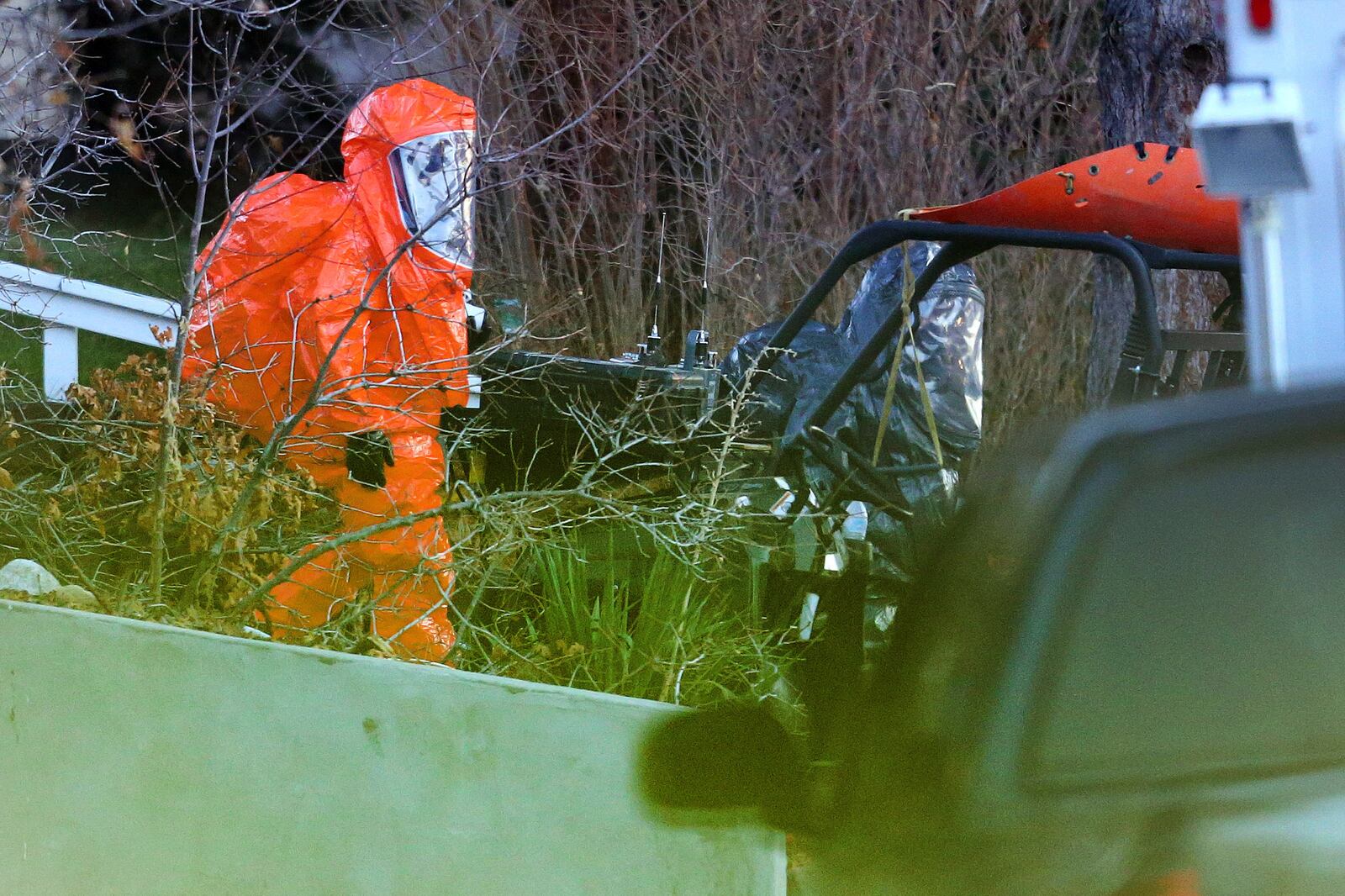 Men in protective suits exit a residence as law enforcement agencies respond to a drug bust in Cottonwood Heights.