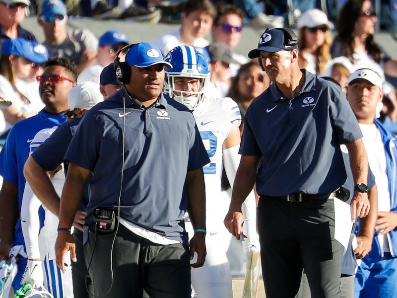 BYU coach Kalani Sitake, left, stands on the sideline as his team plays the Arkansas Razorbacks in Provo, Oct. 15, 2022.