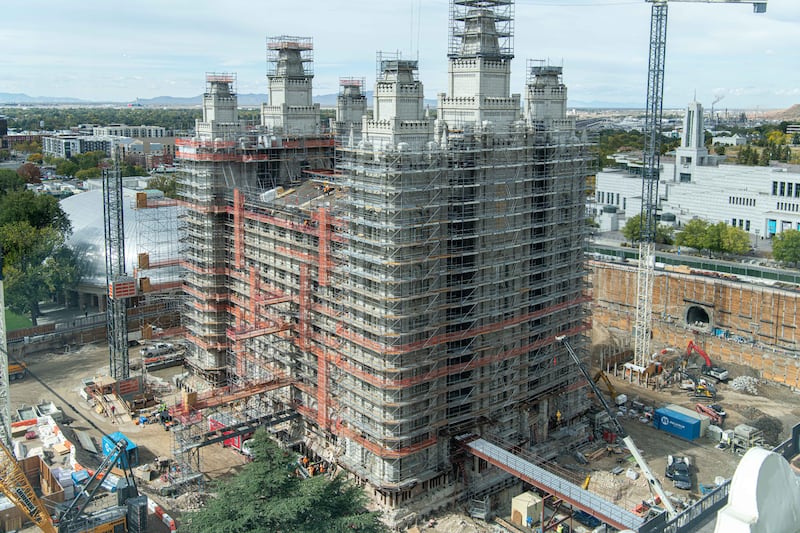 The south and east sides of the Salt Lake Temple are covered by scaffolding and surrounded by construction equipment.