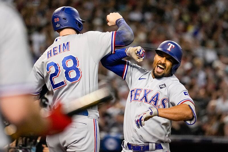 Texas Rangers’ Marcus Semien, right, celebrates his three-run home run with Jonah Heim during Game 4 of the World Series against the Arizona Diamondbacks on Oct. 31, 2023.
