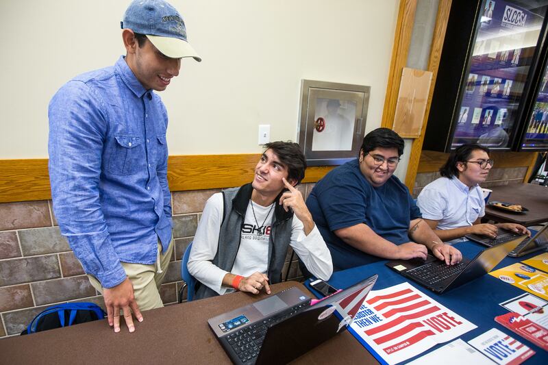 Alvaro Martinez, left, talks to Luis Alvarez about voter registration at the Salt Lake Community College Student Center in Taylorsville on Friday, Oct. 12, 2018.