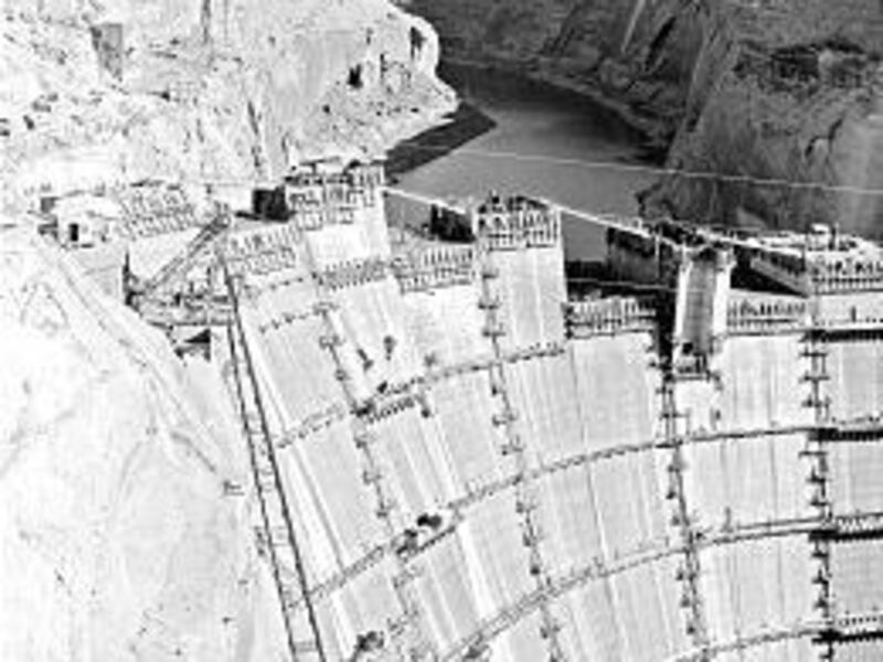 Glen Canyon Dam is seen under construction in 1963, with the Colorado River starting to back up behind it.