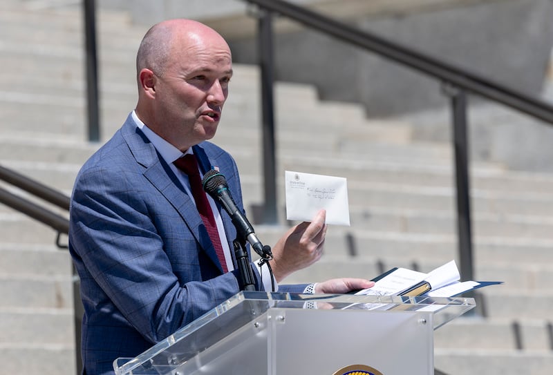 Gov. Spencer Cox holds up a letter he wrote to the people of Utah. The letter was placed inside a time capsule that will be stored inside one of the columns of the Capitol in Salt Lake City on Wednesday, May 18, 2022.