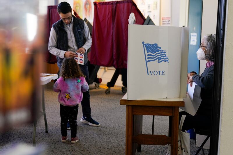 People vote at a polling site in a public library in Englewood, N.J.