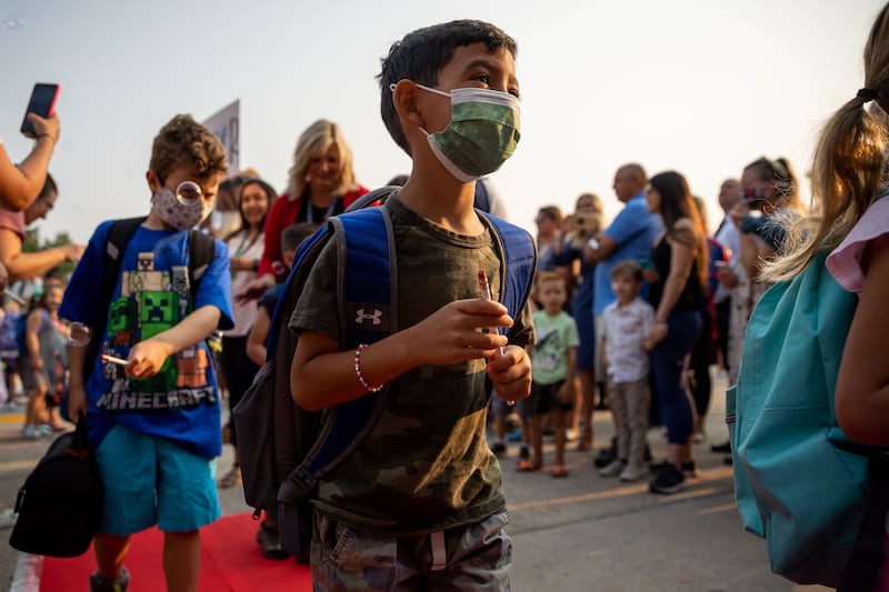 Giancarlo Gonzalez, 6, wears a mask as he arrives for the first day of school at Altara Elementary in Sandy.