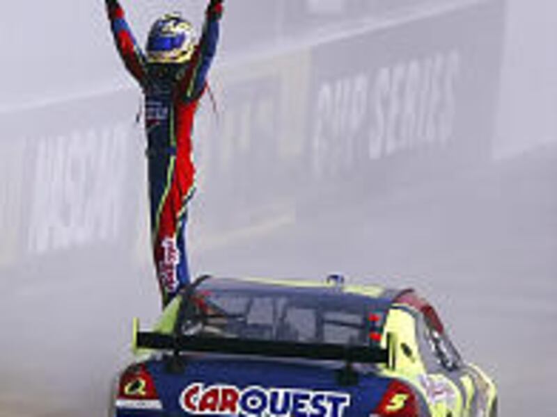 Kyle Busch waves the checkered flag to the crowd after winning the NASCAR Nextel Cup Food City 500 race in Bristol, Tenn.