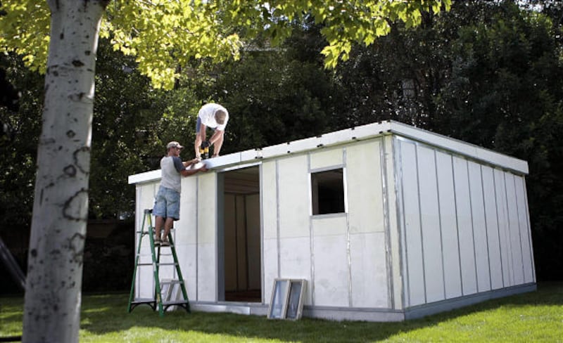 Nick Haslem, left, and Lance Shotwell put finishing touches on a 361-square-foot house of metal and Styrofoam that was put up in less than an hour Wednesday in Draper.
