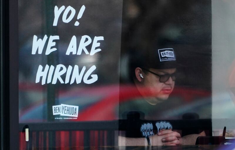 A hiring sign is displayed at a restaurant in Schaumburg, Illinois.