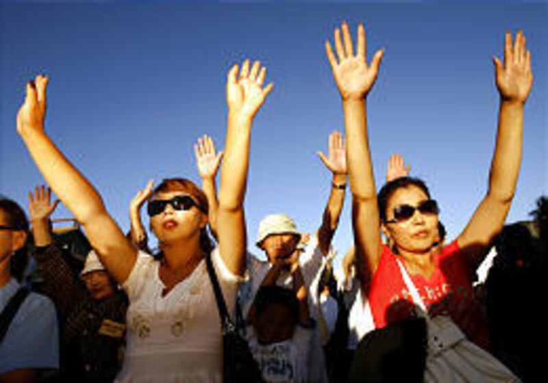 Mongolian Christians raise their arms in praise Wednesday at a rally for evangelist Peter Yongren in Ulan Bator. Mongolia's capital is hosting not only the Dalai Lama and Yongren this week but also Indian guru Sri Sri Ravi Shankar, underscoring the growin