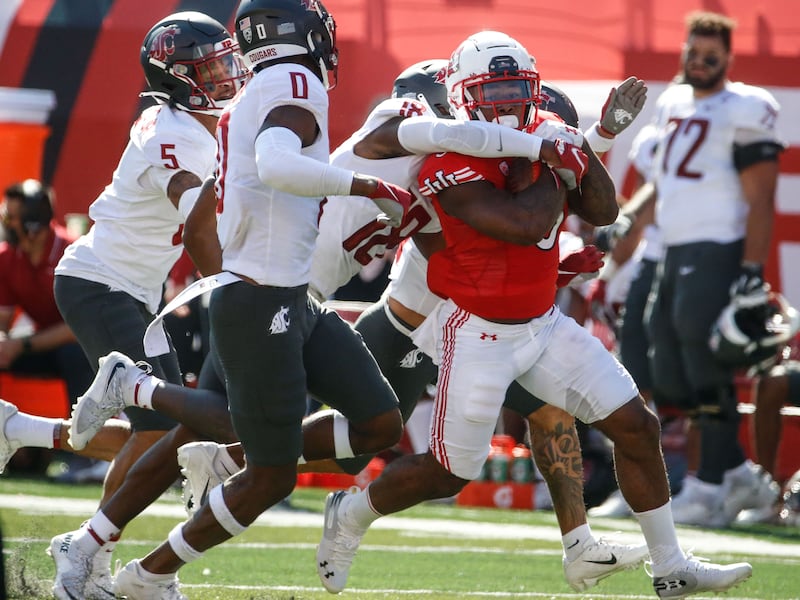 Utah running back T.J. Pledger, right, runs past Washington State defenders Saturday, Sept. 25, 2021 in Salt Lake City.