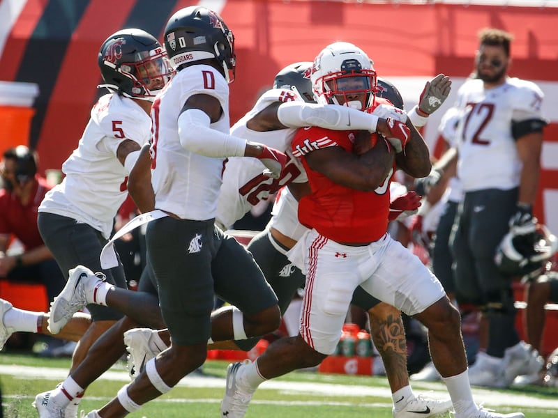 Utah running back T.J. Pledger, right, runs past Washington State defenders Saturday, Sept. 25, 2021 in Salt Lake City.