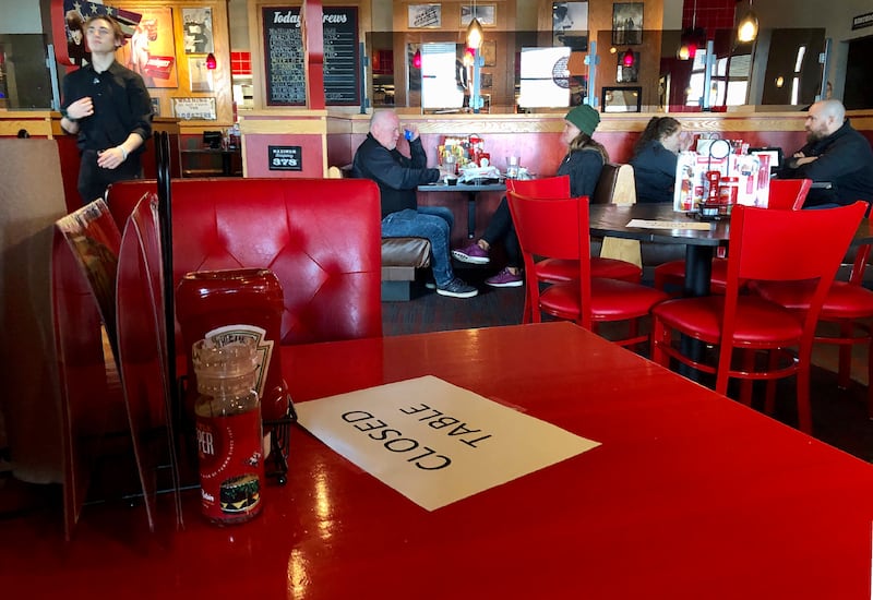 In this March 15, 2020, file photo, a Red Robin restaurant in Tigard, Ore., has closed some tables in order to maintain social distancing between diners per CDC guidelines.