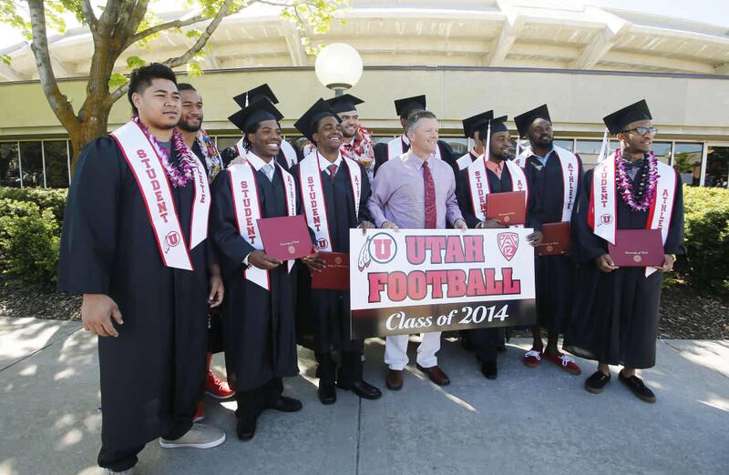 University of Utah football coach Kyle Whittingham and several players pose for a photo after graduation ceremonies in Salt Lake City Friday, May 2, 2014.
