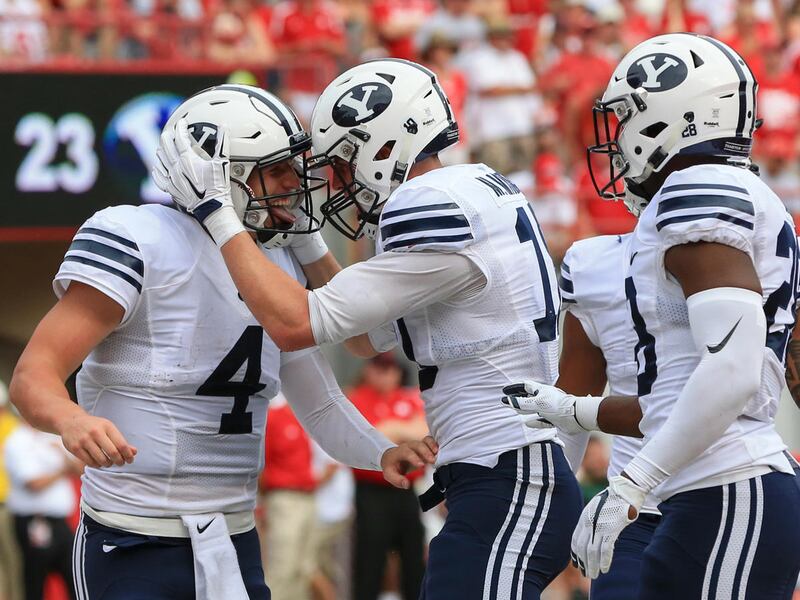 BYU quarterback Taysom Hill (4) and running back Adam Hine, right, celebrate with wide receiver Mitch Mathews (10) after Mathews scored a touchdown against Nebraska during the first half of an NCAA college football game in Lincoln, Neb., Saturday, Sept. 5