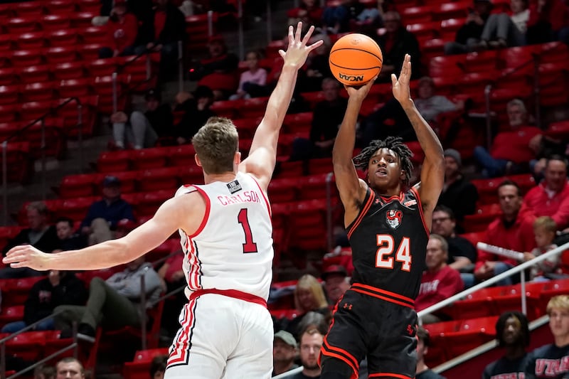 Sam Houston State guard Donte Powers (wearing black) shoots as Utah forward Ben Carlson (wearing white) defends