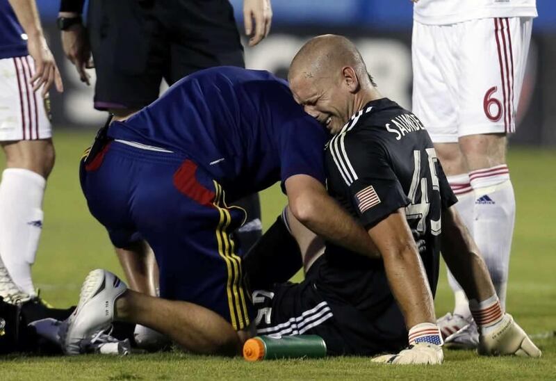 Real Salt Lake's Josh Saunders (45) reacts as he has his left leg checked by a staff member after a collision while making a save on a ball in the first half an MLS soccer game against FC Dallas, Saturday, July 13, 2013, in Frisco, Texas. Saunders underwe