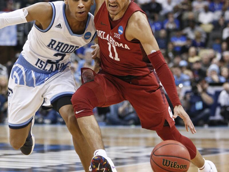 Oklahoma's Trae Young (11) drives as Rhode Island's Fatts Russell (2) defends during the second half of an NCAA men's college basketball tournament first-round game, Thursday, March 15, 2018, in Pittsburgh. Rhode Island won 83-78 in overtime to advance to