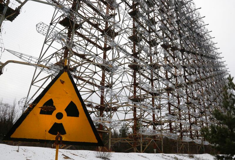 A Soviet-era top secret object Duga behind a radioactivity sign in Chernobyl, Ukraine.