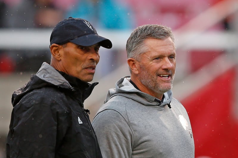 Arizona State coach Herm Edwards, left, and Utah coach Kyle Whittingham speak before a game Saturday, Oct. 19, 2019, in Salt Lake City.